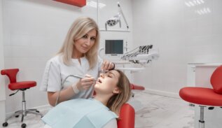 Стоматолог-терапевт лечит зубы пациентки